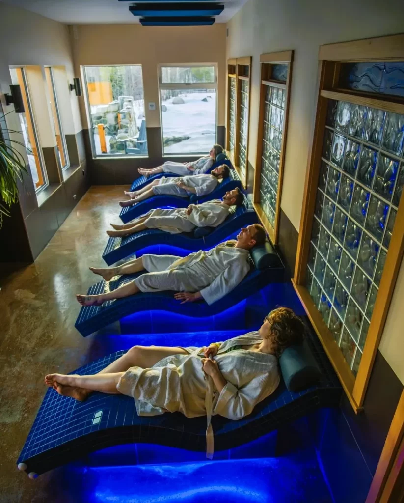 people in robes relaxing on chaise lounges